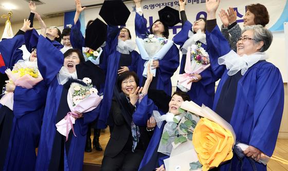 학사모 던지며 졸업 기뻐하는 만학도들