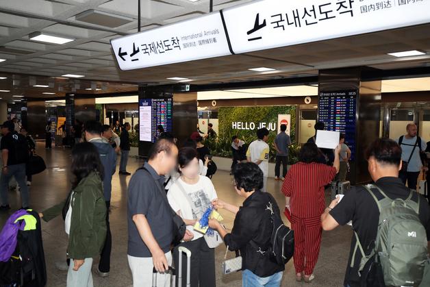'황금연휴 코앞' 제주공항 귀성·관광객 북적…노동자는 "투쟁" 연호